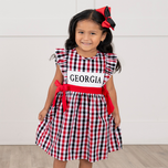 young girl wearing Georgia gingham dress against white background