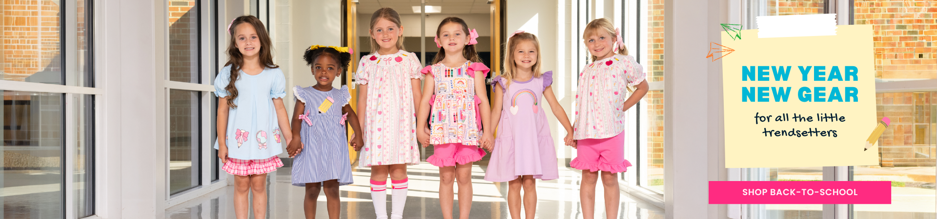 Young girls wearing back to school outfits in school hallway - shop back to school
