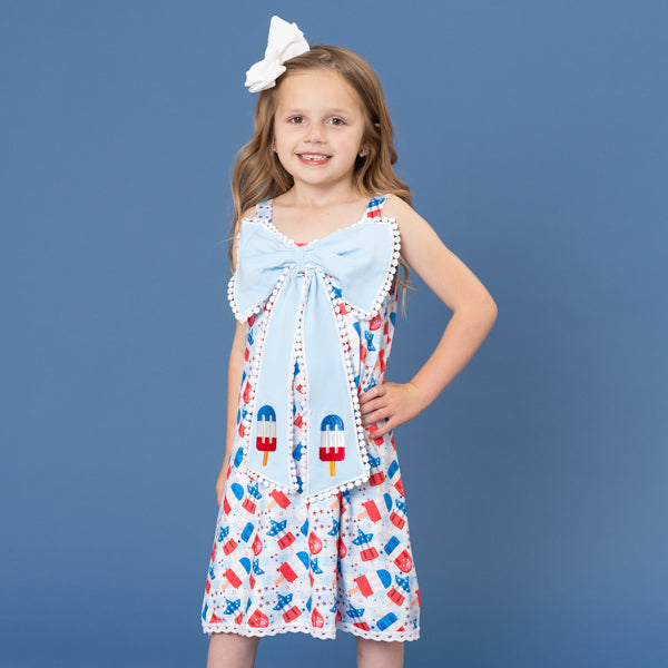 Young girl wearing a dress with ice cream cone pattern against a blue background
